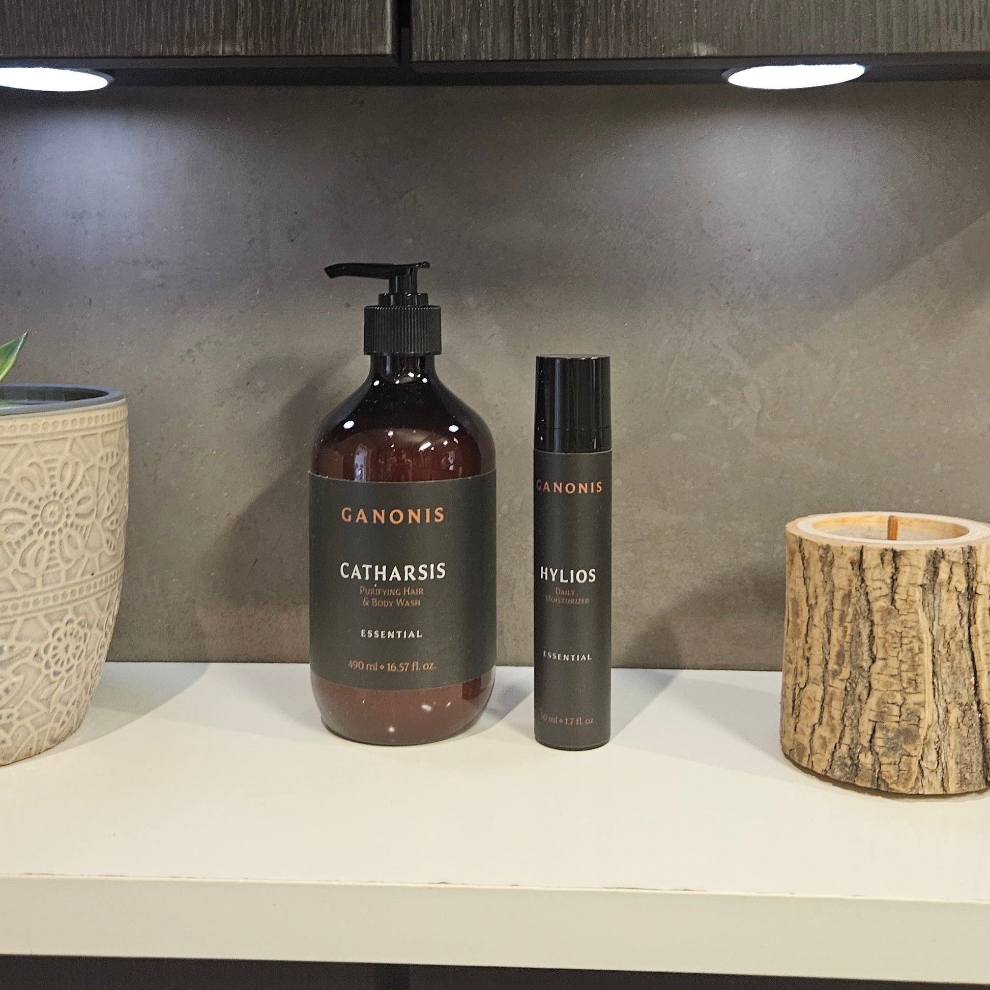 Bathroom counter with bottles and a wooden container on a neutral background